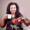 Getrude Mumgai holding a cup and a box of Chai Mfalme